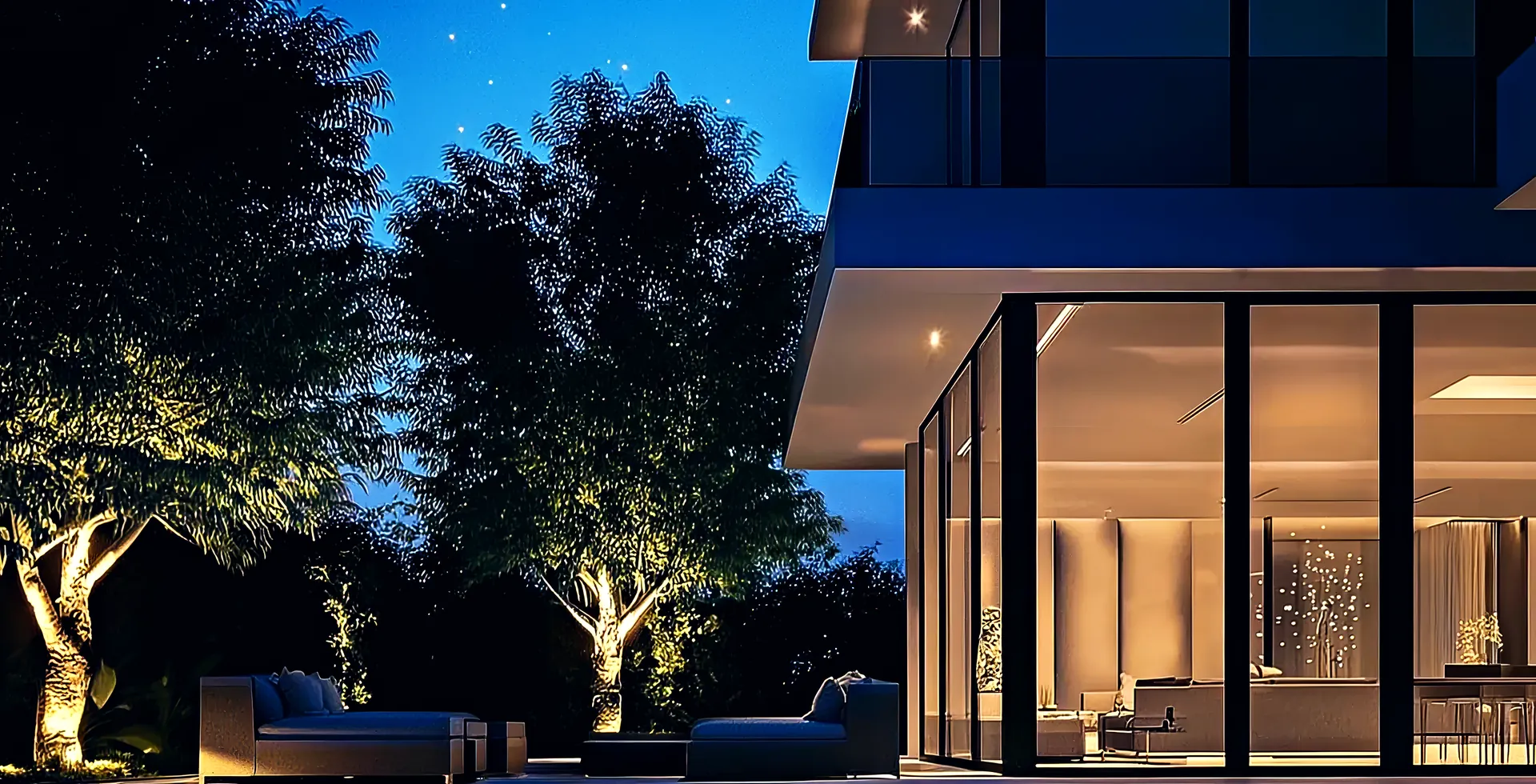 A finished villa lit at night among its trees